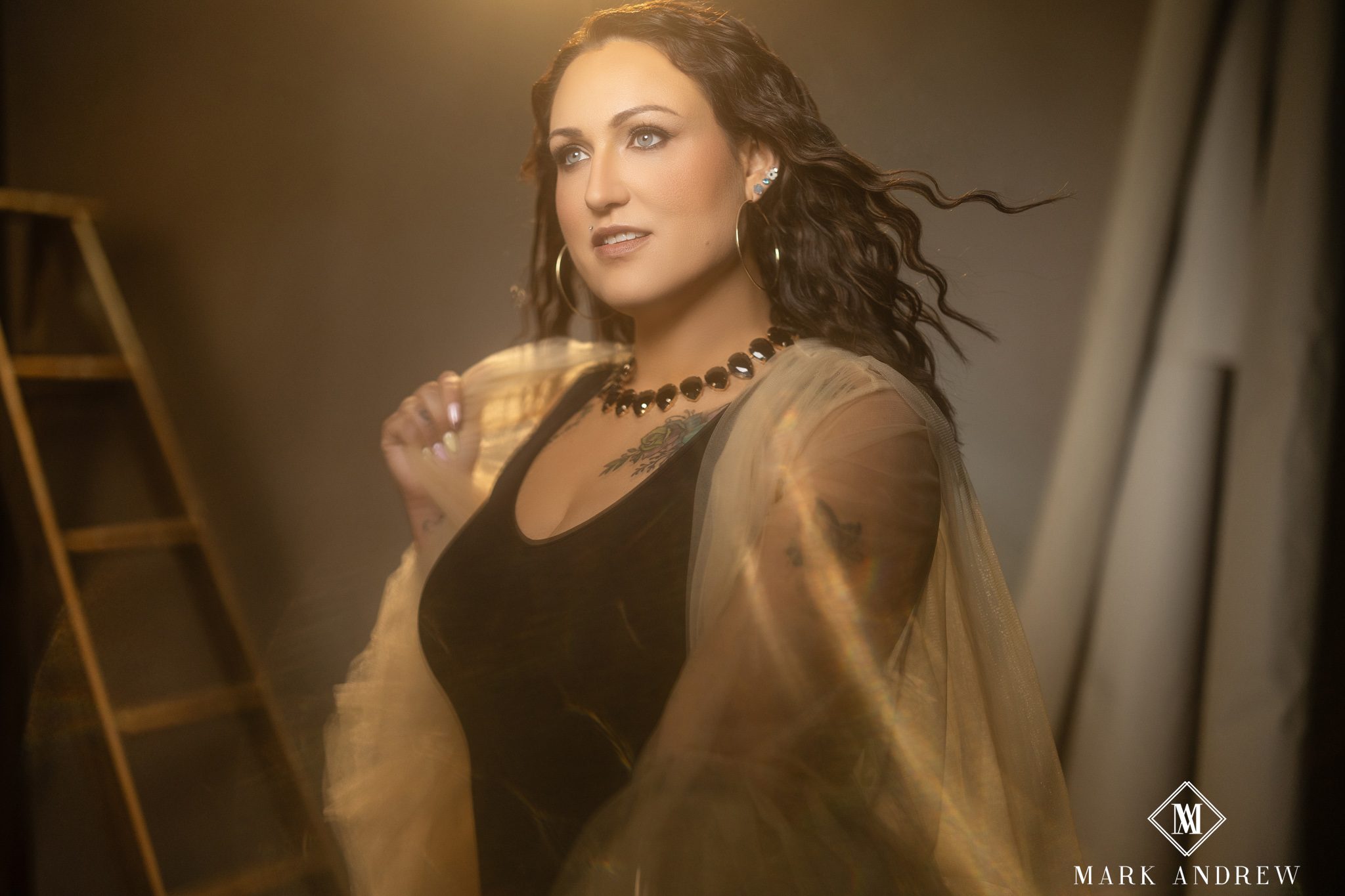Woman with polished hair and camera-ready makeup in warm golden light during a Michiana boudoir session