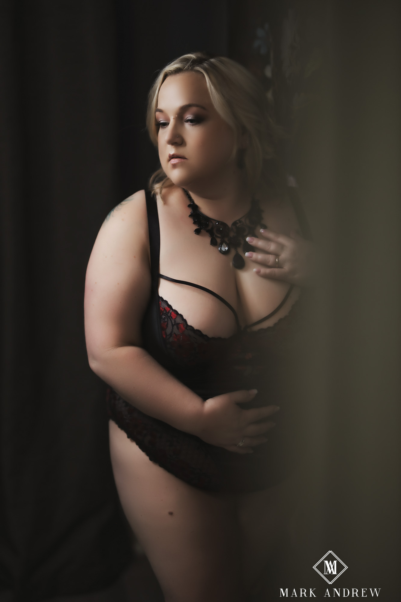 Becky in black and red lace with dramatic side light, contemplative pose — intimate boudoir portrait, Niles Michigan area