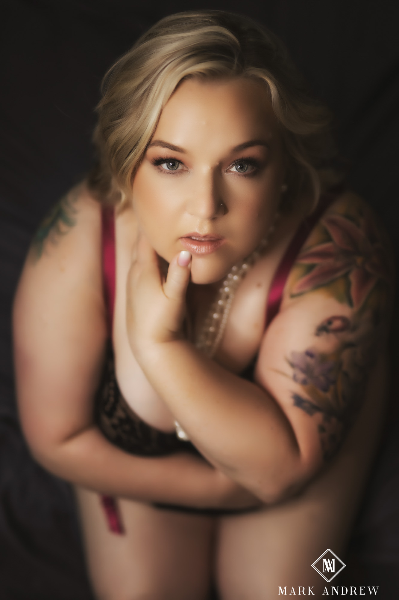 Becky in red lingerie and pearls looking up — the image she chose as the acrylic cover of her first boudoir album, South Bend Indiana