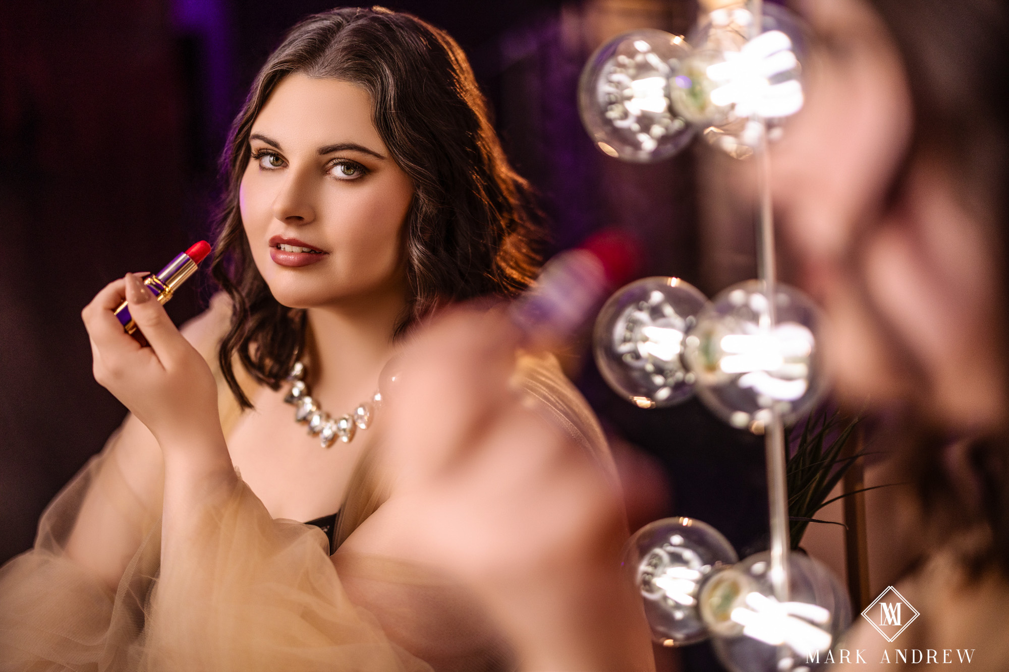 Katherine at a vanity mirror with a red lipstick, diamond necklace, and peach tulle robe — Hollywood-glam boudoir vanity portrait