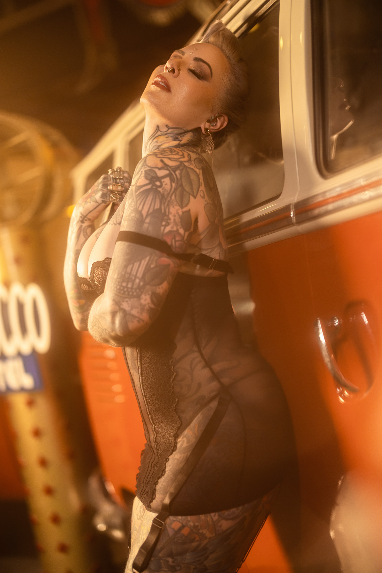 Boudoir client in sheer mesh bodysuit with tattoos and vintage VW bus backdrop